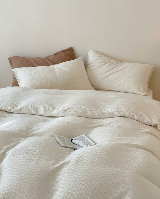 Pearl muslin cotton double gauze duvet cover and pillowcases with a brown accent pillow and open book