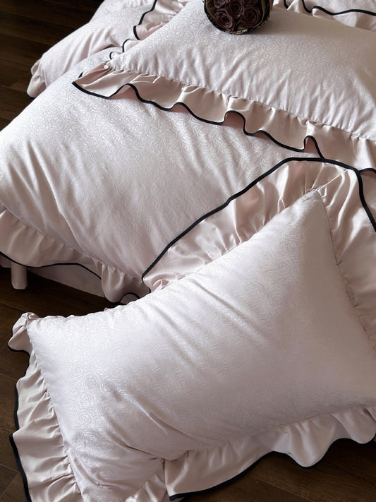 Rose jacquard cotton sateen detail on the Camellia Ruffled Duvet Cover Set in Quartz with ruffled edges
