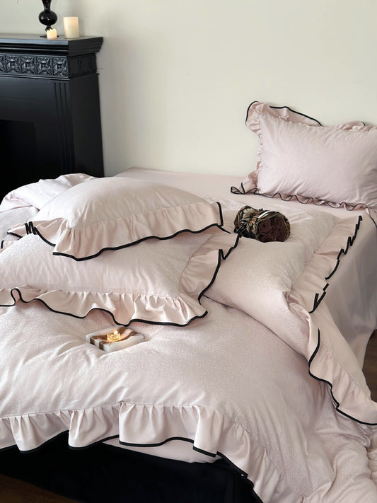 Camellia Ruffled Duvet Cover Set in Quartz with ruffled shams and black trim in a styled bedroom