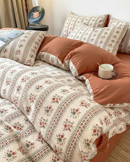 Retro floral duvet cover set in terracotta tones with soft draping fabric, cozy bedroom styling and natural light
