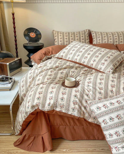 Retro terracotta bedding set with floral pattern and soft pillows, cozy bedroom styling with cup and natural textures