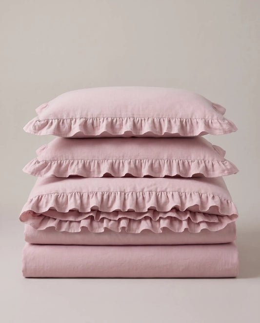 Folded blush pink ruffle bedding set featuring soft washed cotton fabric and romantic layered ruffle trim by DORMÉ Studio