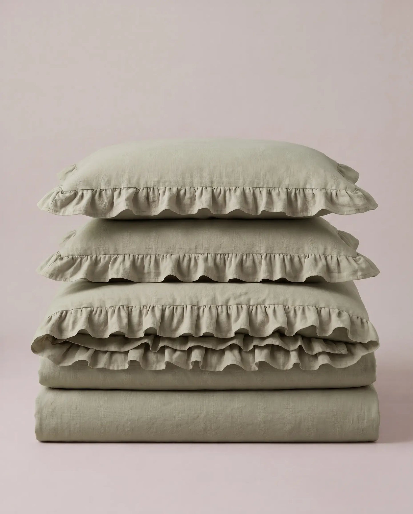 Folded eucalyptus sage ruffle bedding set showcasing soft washed cotton fabric and elegant layered ruffle detailing by DORMÉ Studio