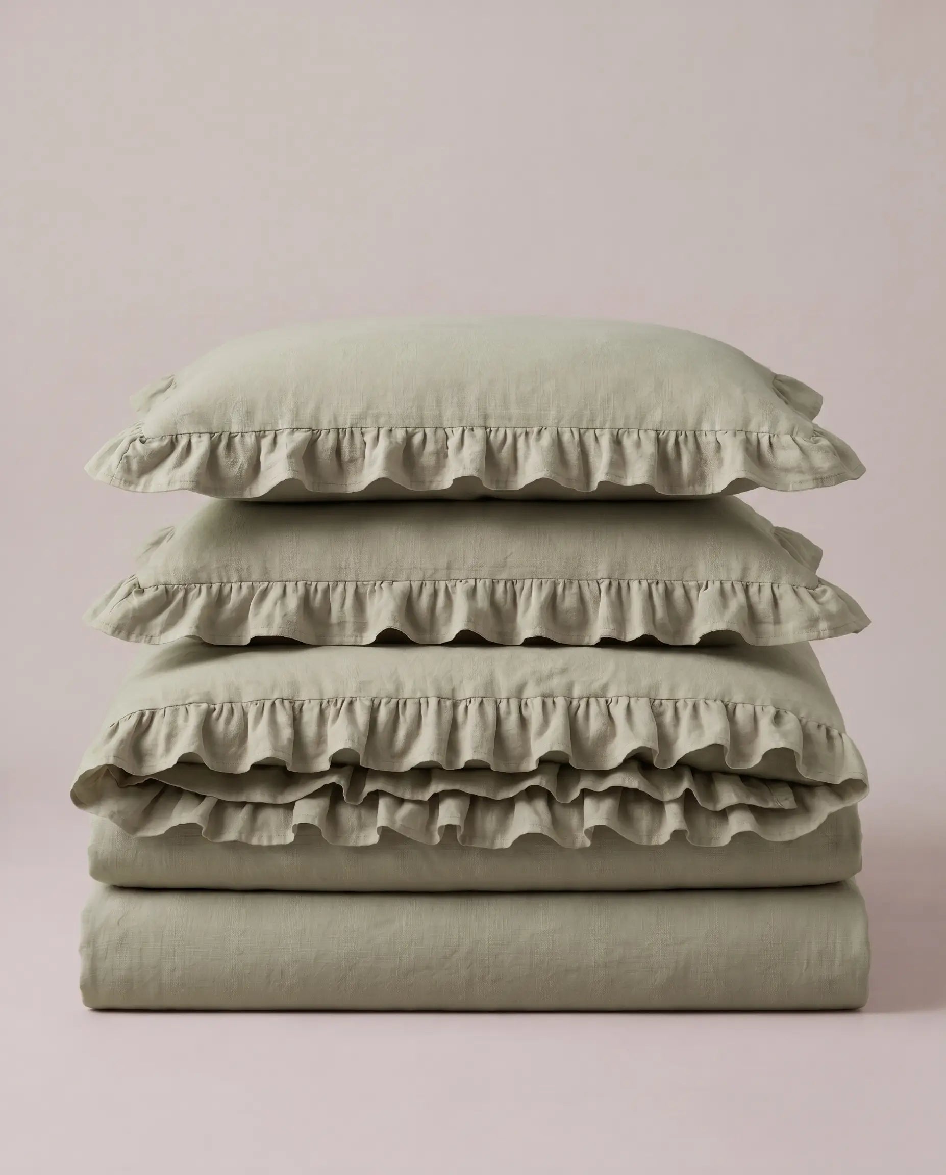 Folded eucalyptus sage ruffle bedding set showcasing soft washed cotton fabric and elegant layered ruffle detailing by DORMÉ Studio