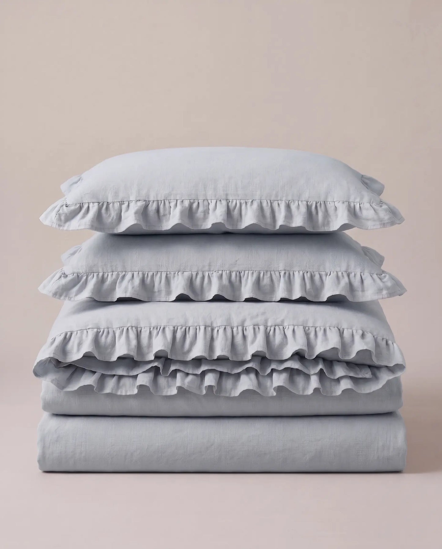 Folded mist blue ruffle bedding set showcasing soft washed cotton texture and elegant layered trim by DORMÉ Studio
