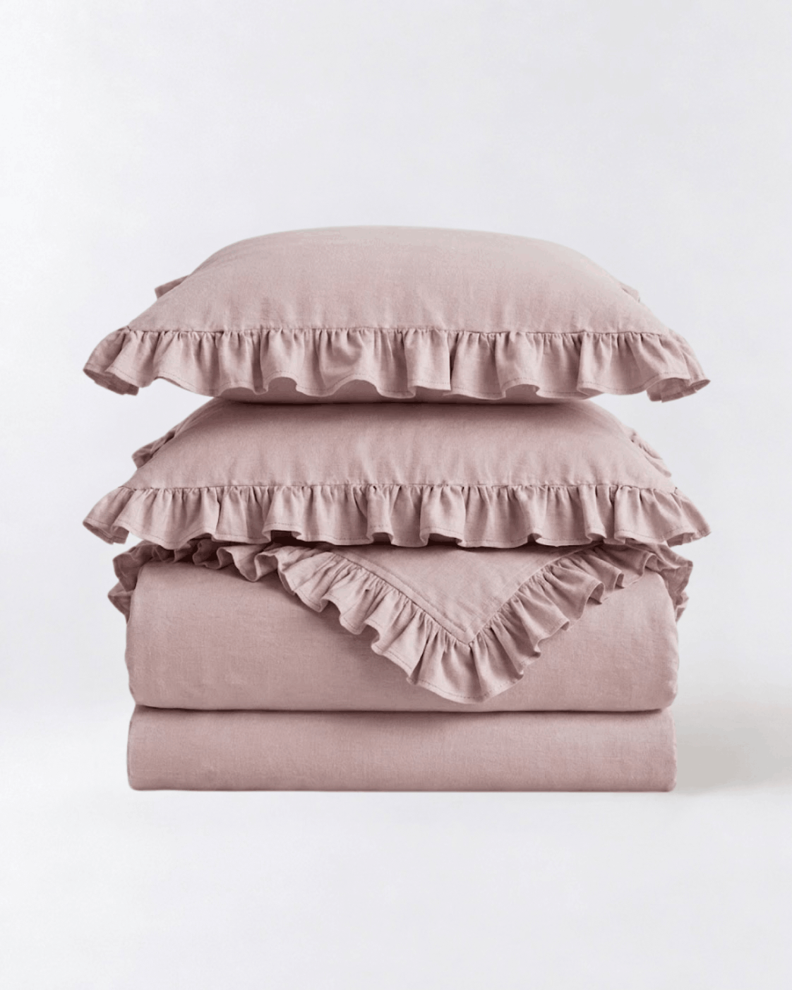 Folded blush pink ruffle bedding set featuring soft washed cotton fabric and romantic layered ruffle trim by DORMÉ Studio