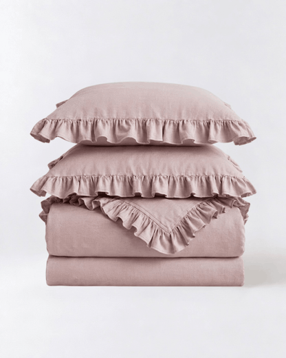Folded blush pink ruffle bedding set featuring soft washed cotton fabric and romantic layered ruffle trim by DORMÉ Studio