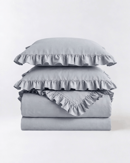 Folded mist blue ruffle bedding set showcasing soft washed cotton texture and elegant layered trim by DORMÉ Studio
