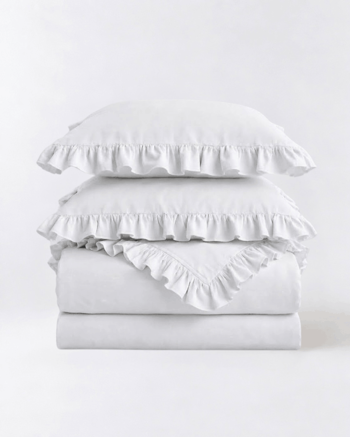 Folded snow white ruffle bedding set showcasing soft washed cotton fabric and elegant layered ruffle detailing by DORMÉ Studio
