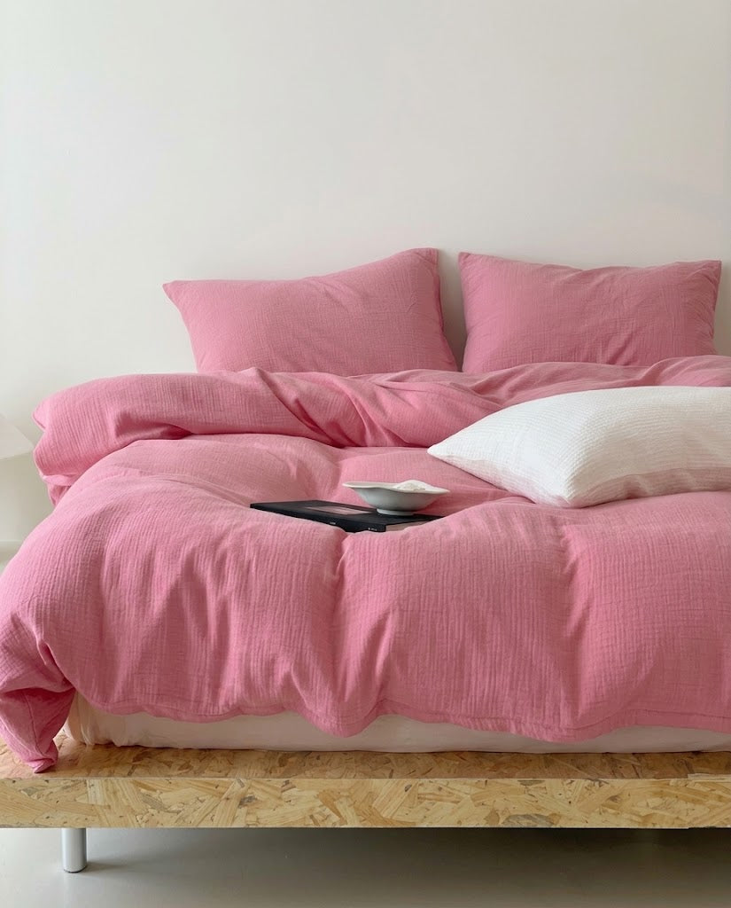 Amalfi Rose muslin cotton double gauze duvet cover set on a wooden platform bed with a white textured pillow