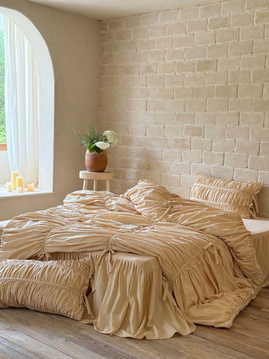 Royal Ruched Duvet Cover Set with ruffled bed skirt and ruched pillowcases in cream washed cotton in a sunlit bedroom