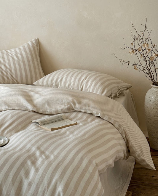 Sable Stripe duvet cover folded back to show the fine pinstripe reverse, with matching striped pillowcases