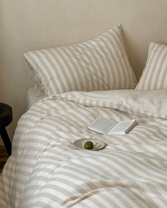 Close-up of washed cotton linen striped duvet cover in oatmeal and cream with pinstripe reverse