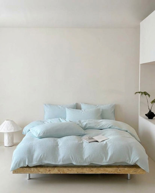 Seafoam Amalfi muslin cotton duvet cover set on a low platform bed in a minimal bedroom
