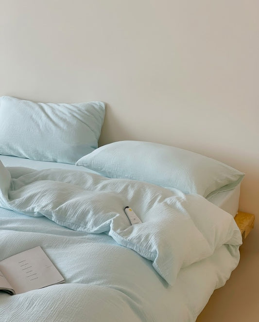 Relaxed Seafoam muslin cotton double gauze duvet cover and pillowcases on an unmade bed