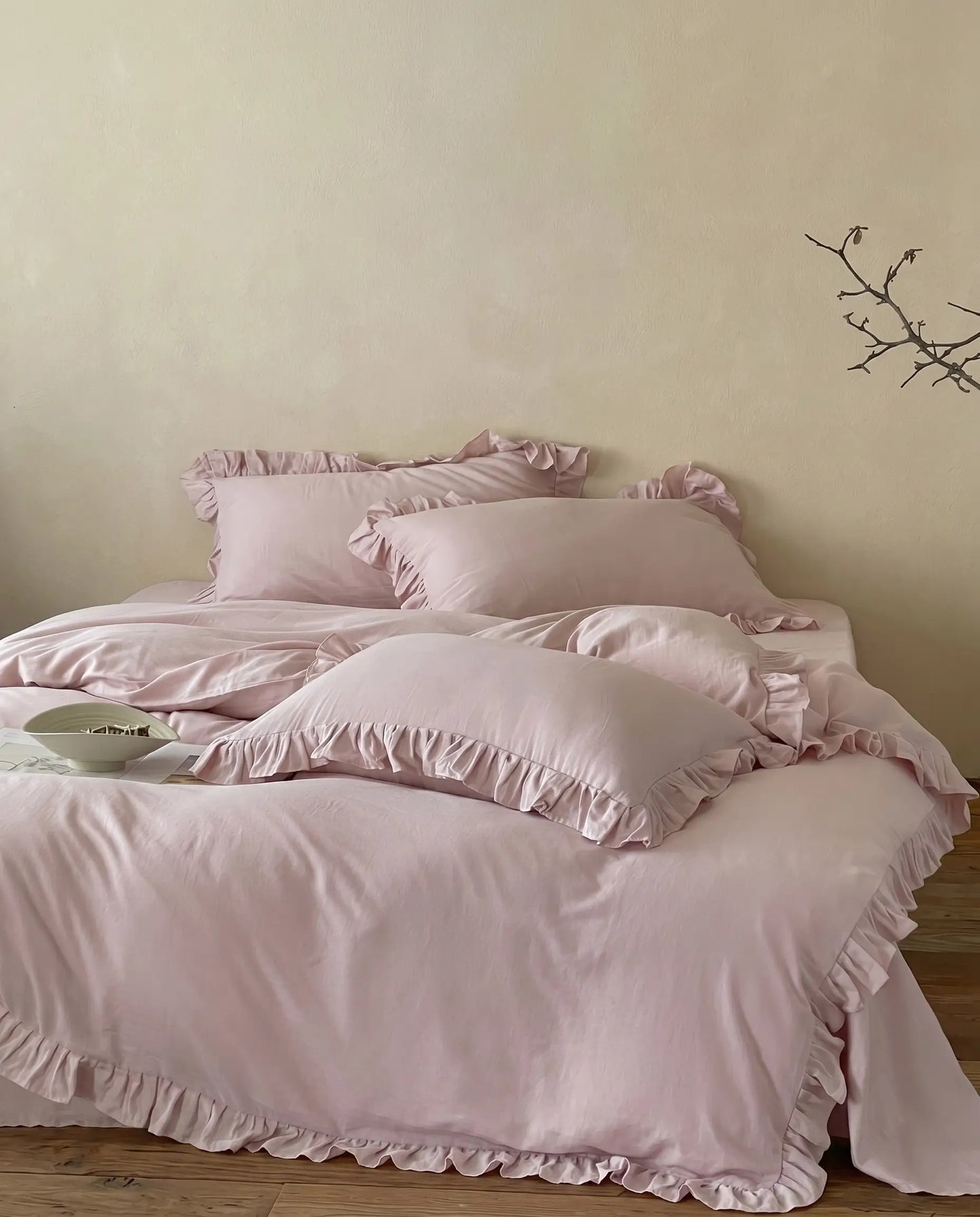 Soft blush pink ruffle bedding styled with layered pillows and elegant feminine bedroom decor aesthetic by DORMÉ Studio