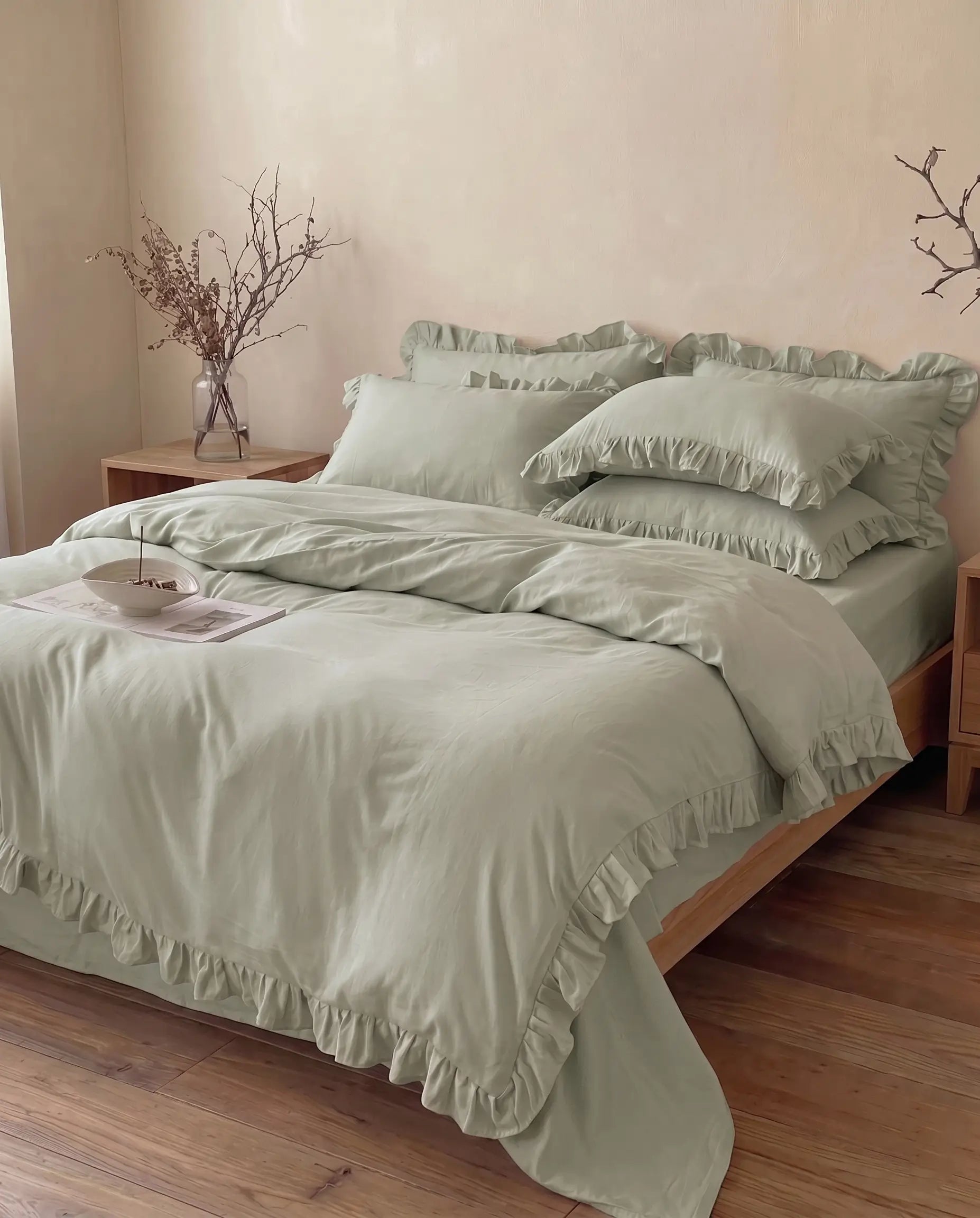 Soft eucalyptus sage green ruffle bedding styled in a calm minimalist bedroom with luxury cotton texture by DORMÉ Studio