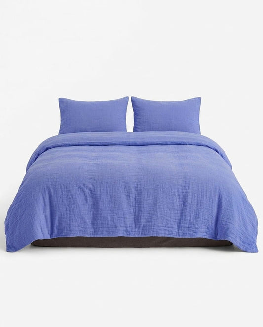 Amalfi muslin duvet cover set in Ultramarine on a queen bed, front view