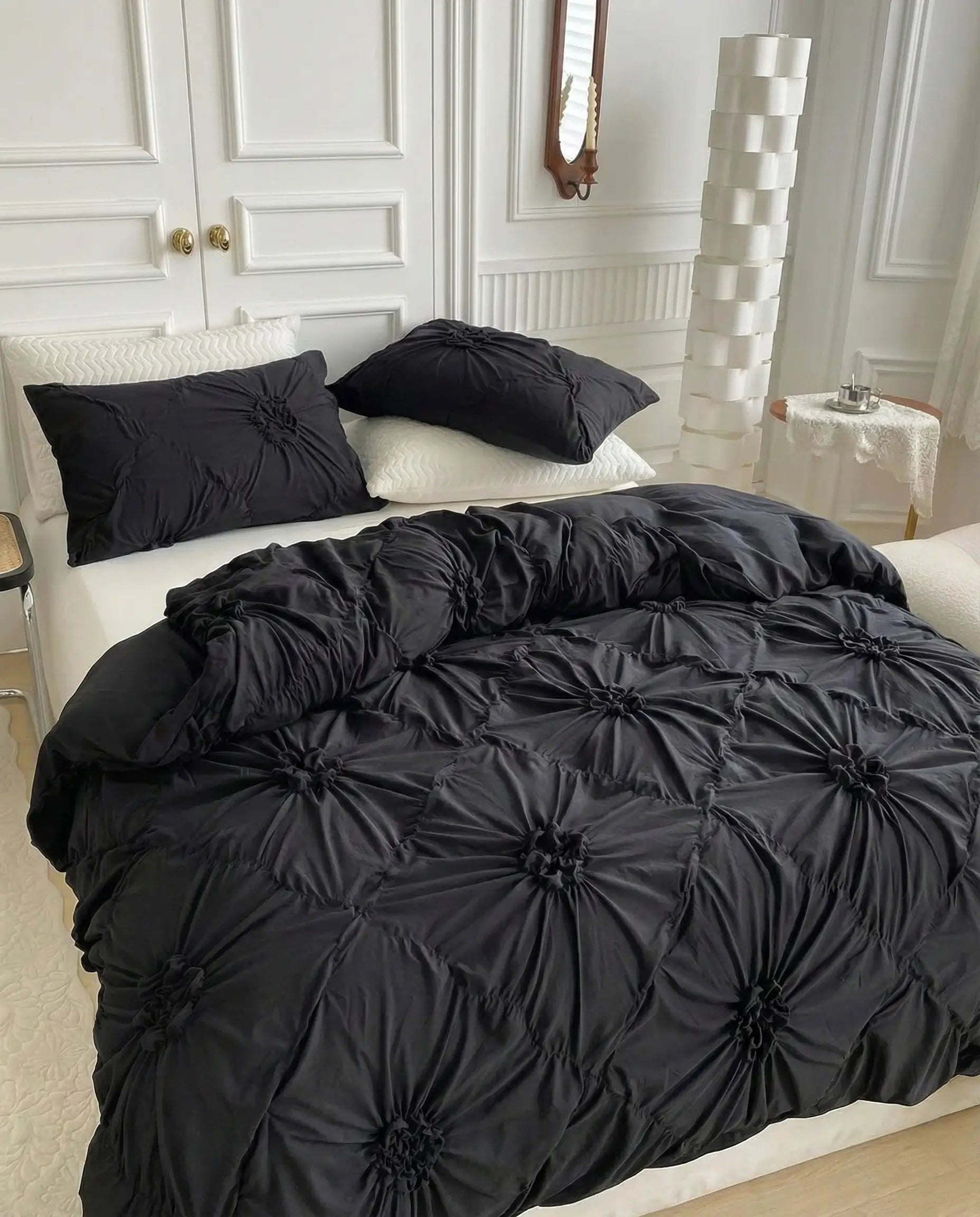 Angled view of black tufted duvet cover highlighting dimensional floral texture and soft drape