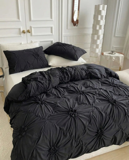 Angled view of black tufted duvet cover highlighting dimensional floral texture and soft drape