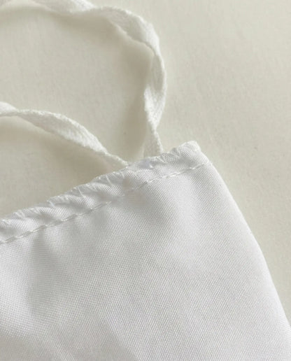 Close up of stitched corner seam on white ruched duvet cover showing clean construction