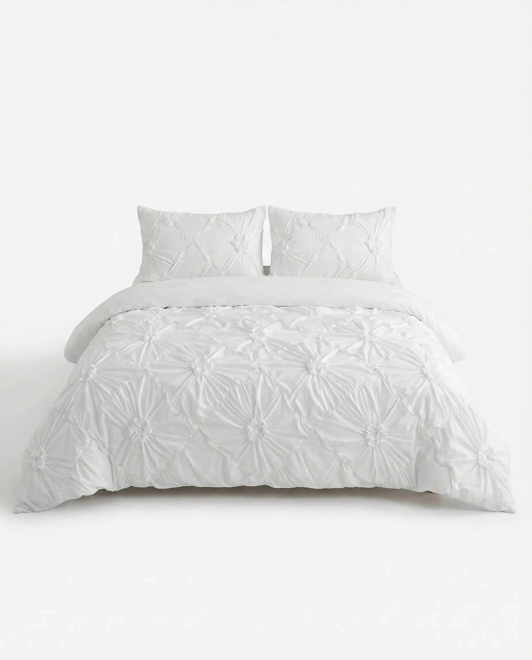 White ruched duvet cover set with textured gathered detailing styled on bed against clean white background