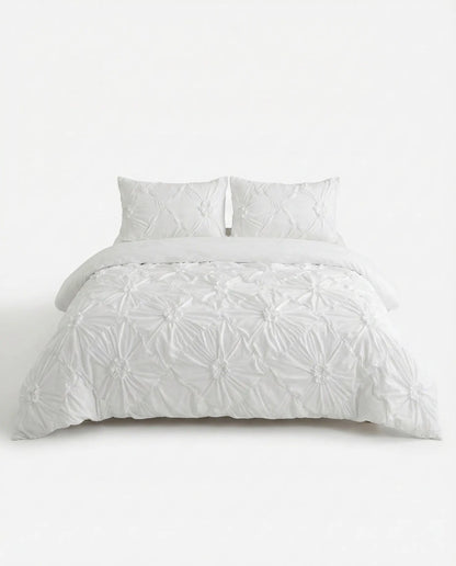 White ruched duvet cover set with textured gathered detailing styled on bed against clean white background