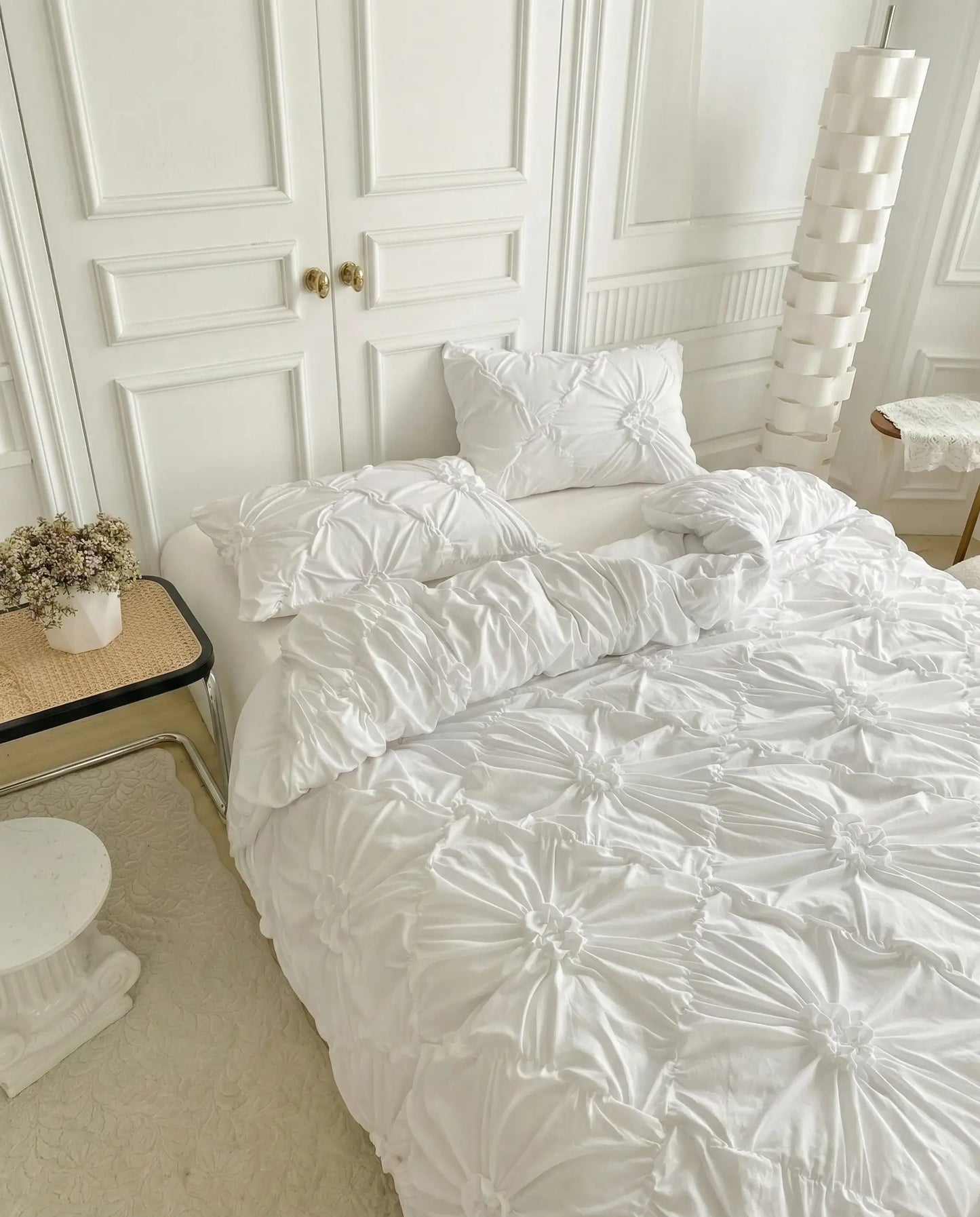 Textured white duvet cover with ruched detailing styled on bed in minimal neutral bedroom