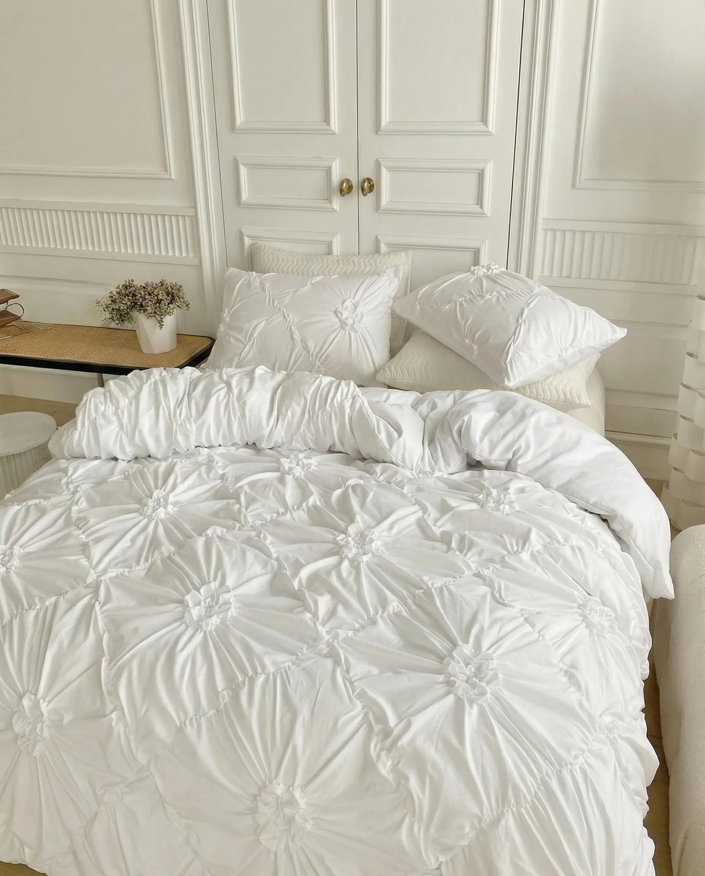 White ruched duvet cover set with matching pillow shams styled in airy contemporary bedroom