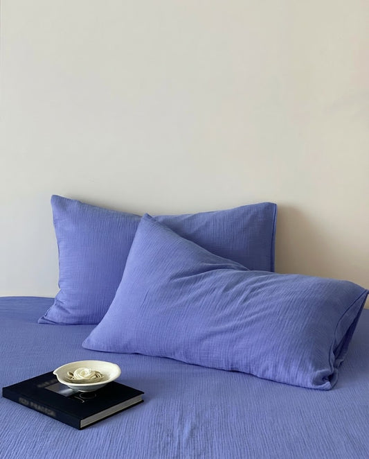 Close-up of Ultramarine muslin pillowcases showing crinkled cotton gauze texture