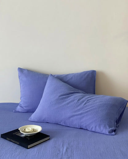 Close-up of Ultramarine muslin pillowcases showing crinkled cotton gauze texture