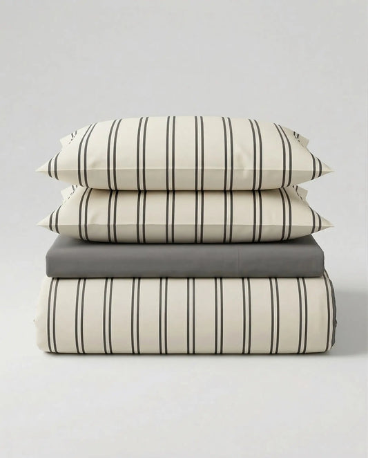 Stacked view of the DORMÉ Studio Urban Stripe Duvet Cover Set featuring soft ivory cotton bedding with thin charcoal pinstripes and matching pillow shams. This modern striped duvet cover set offers a clean, minimalist aesthetic and timeless neutral design that elevates any bedroom with hotel-inspired comfort and refined style.